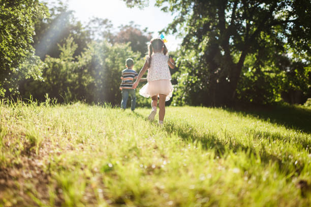 Children running joyfully in sunny park