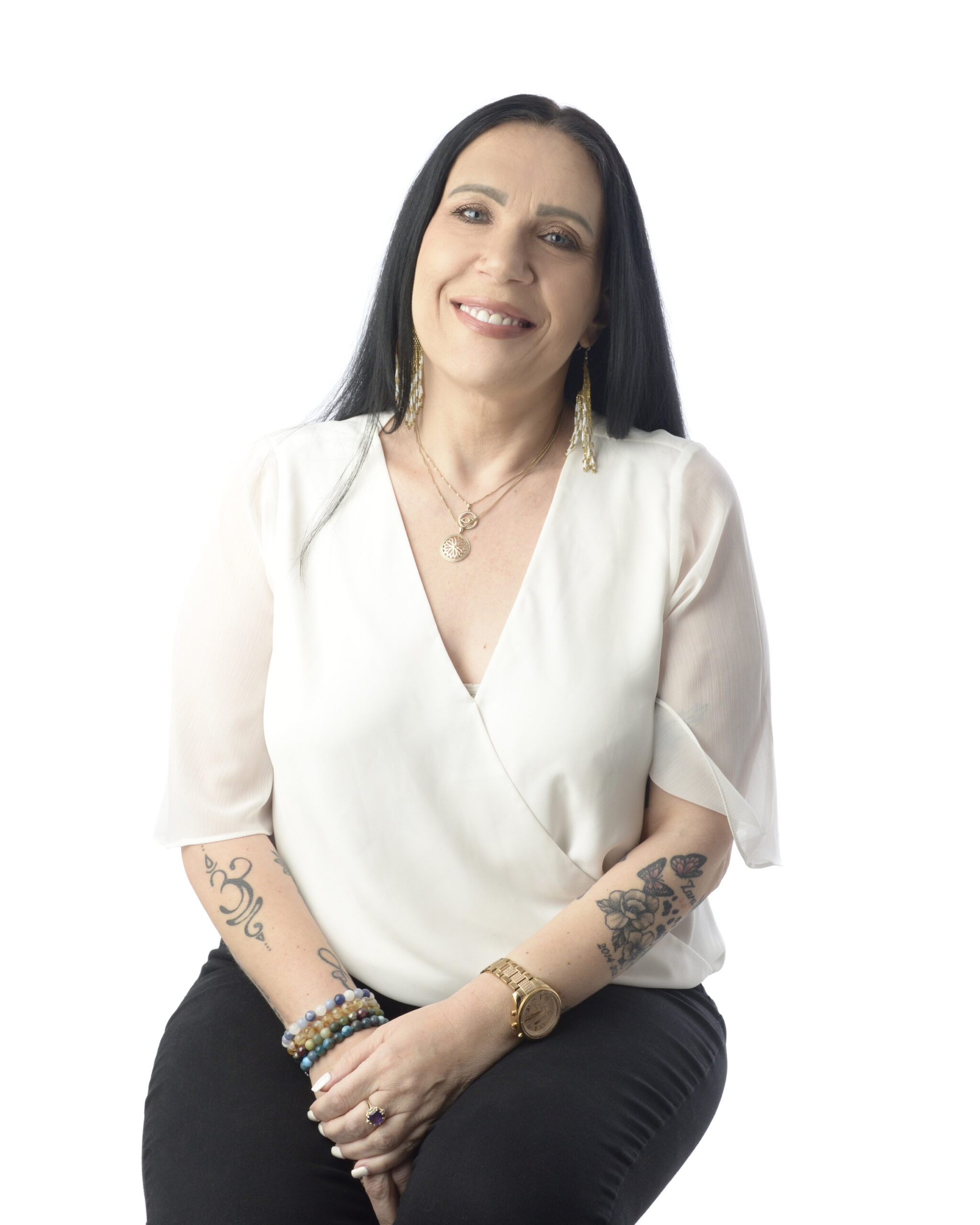 Smiling woman with tattoos wearing white blouse